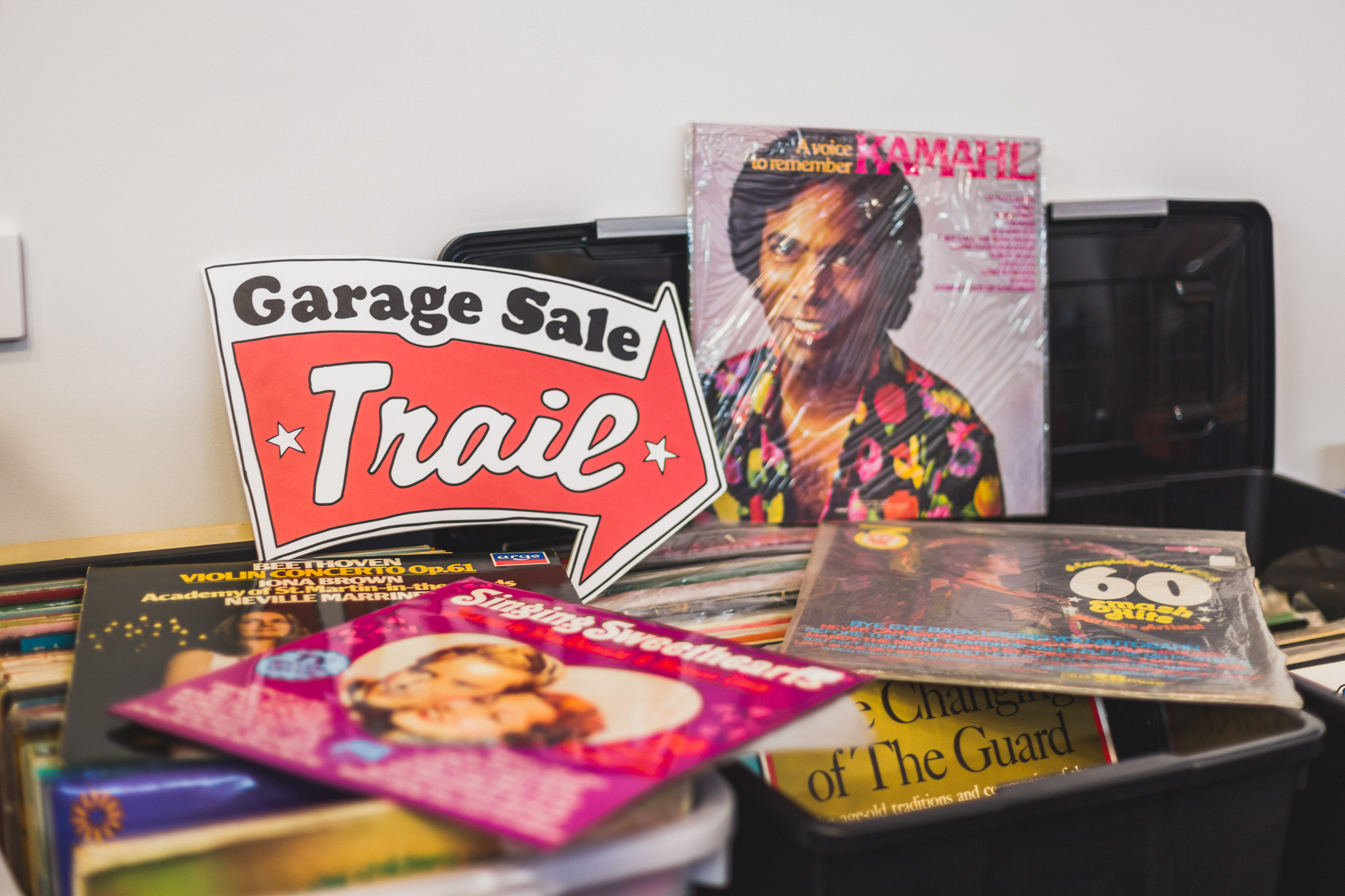 vinyl records on table with Garage Sale Trail sign