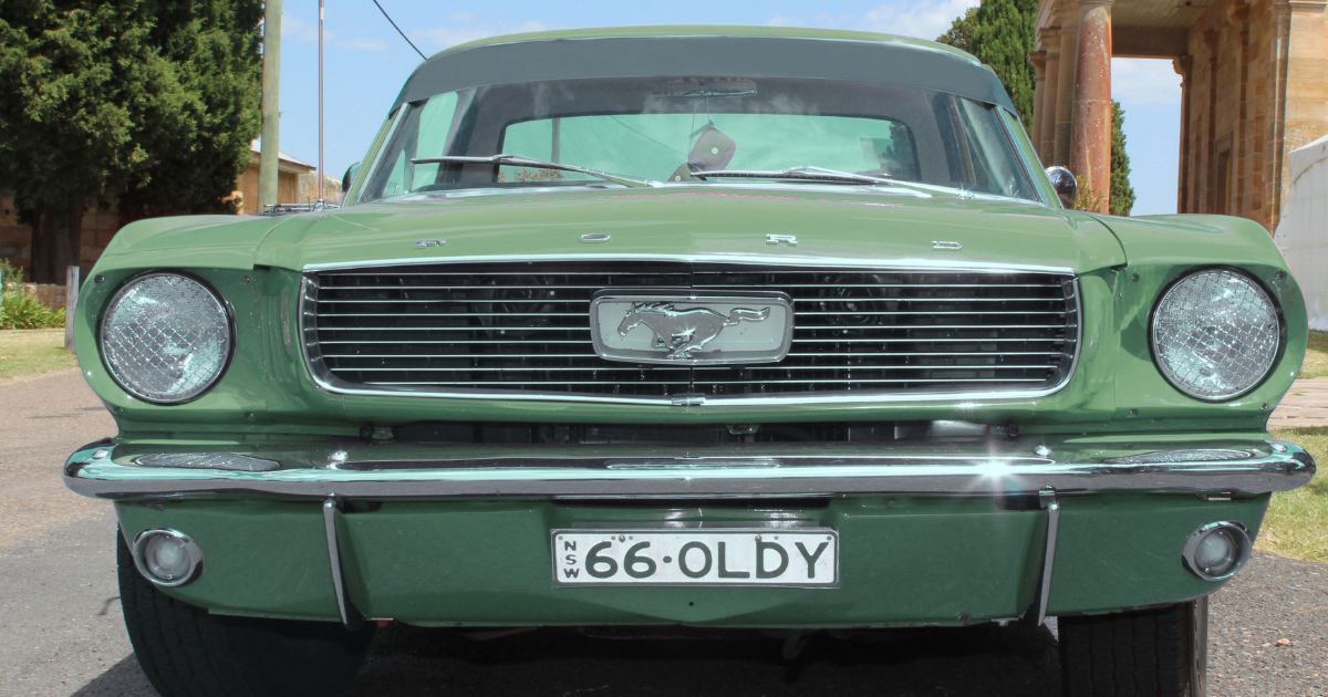 Close up of muted green Ford Mustang parked in from of Berrima Court House