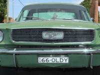 Close up of muted green Ford Mustang parked in from of Berrima Court House