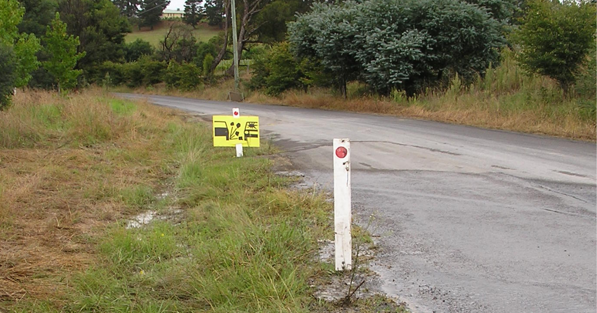 Corner of road with warning sign for loose gravel