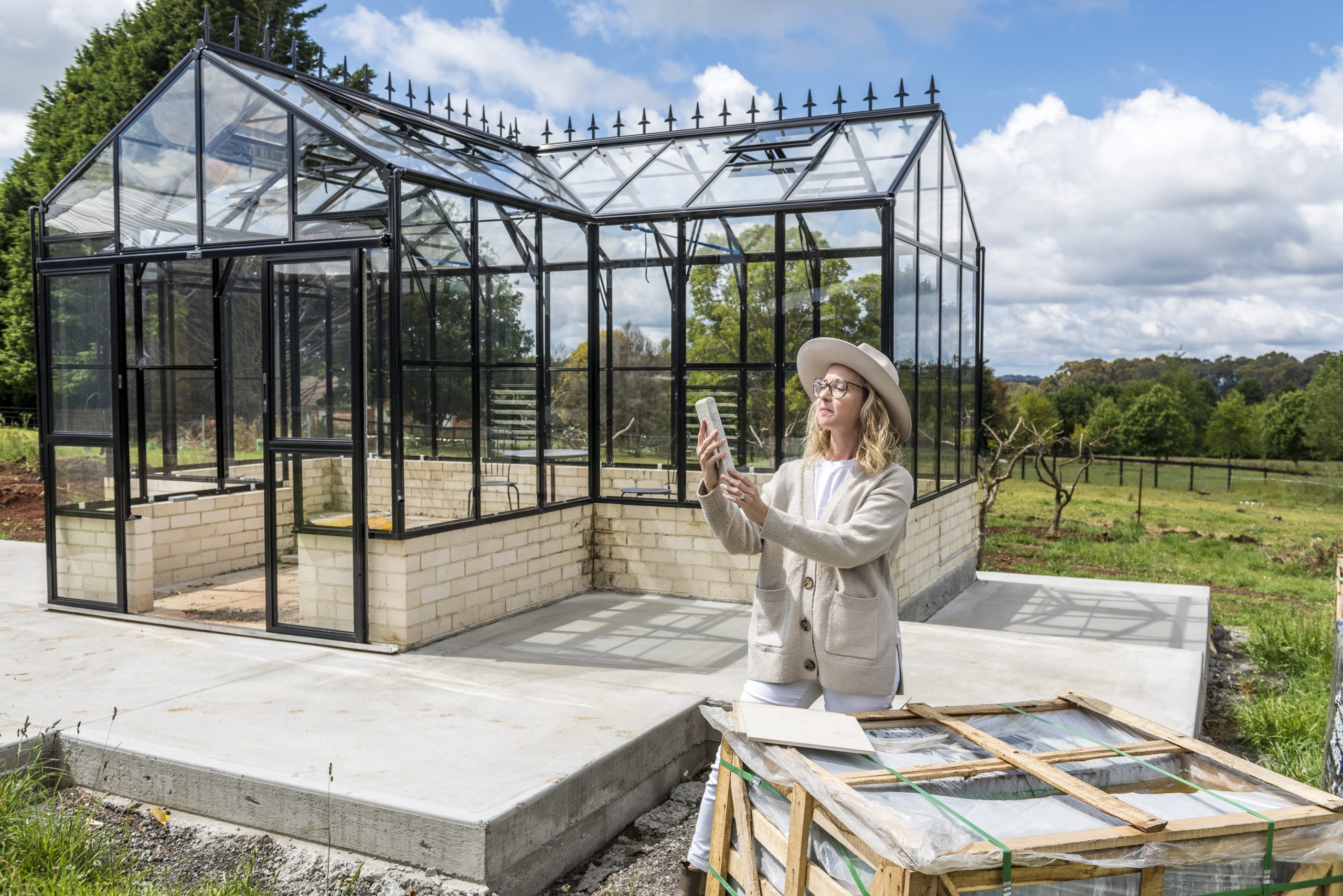 Lady standing near her gazebo and looking at building materials