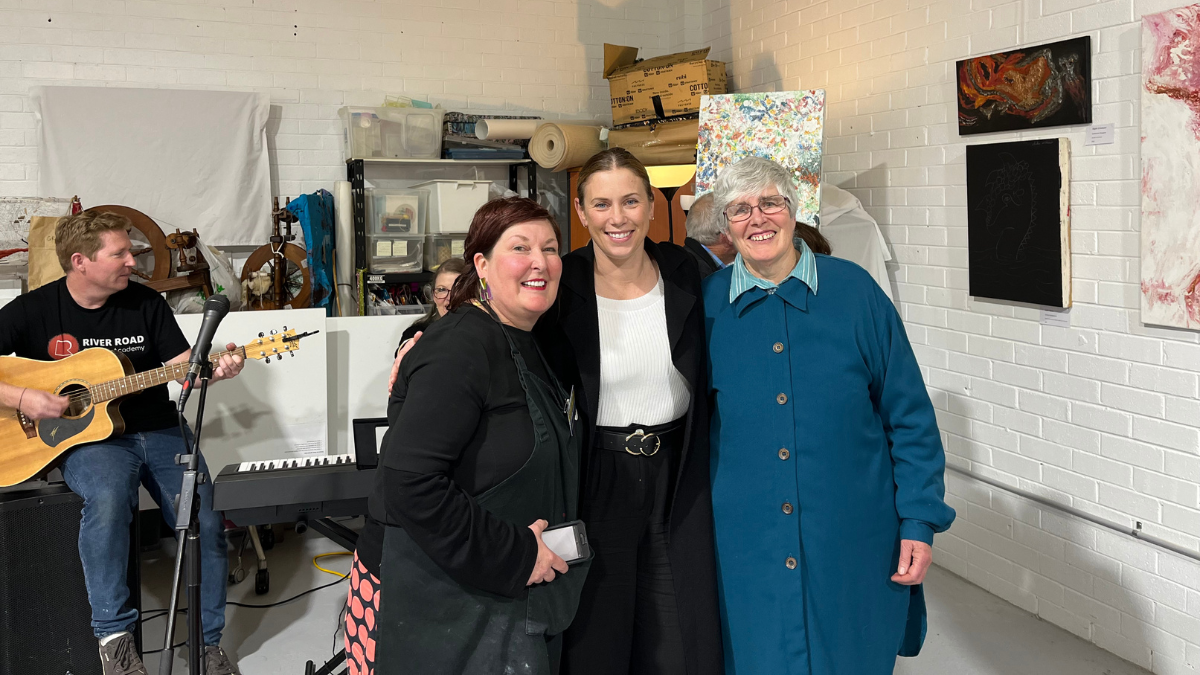 3 women smiling at the camera in the art studio