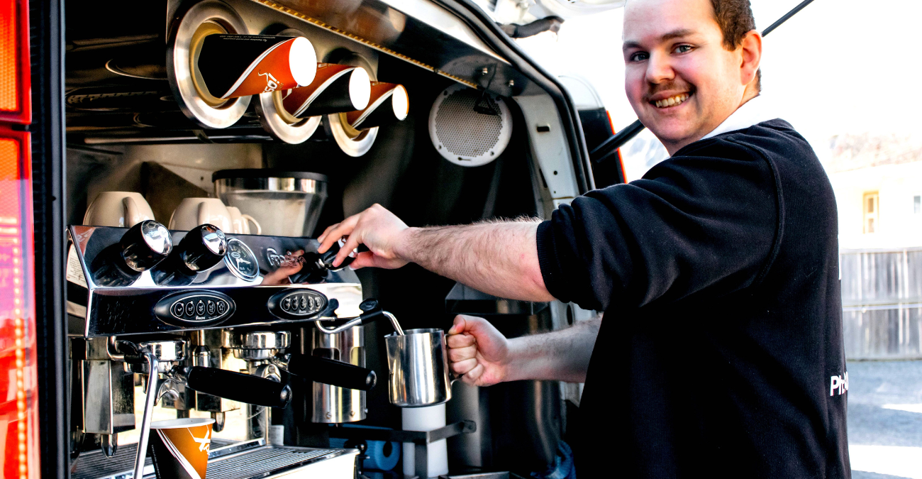 Picture of young man operating the cofee machine in the van